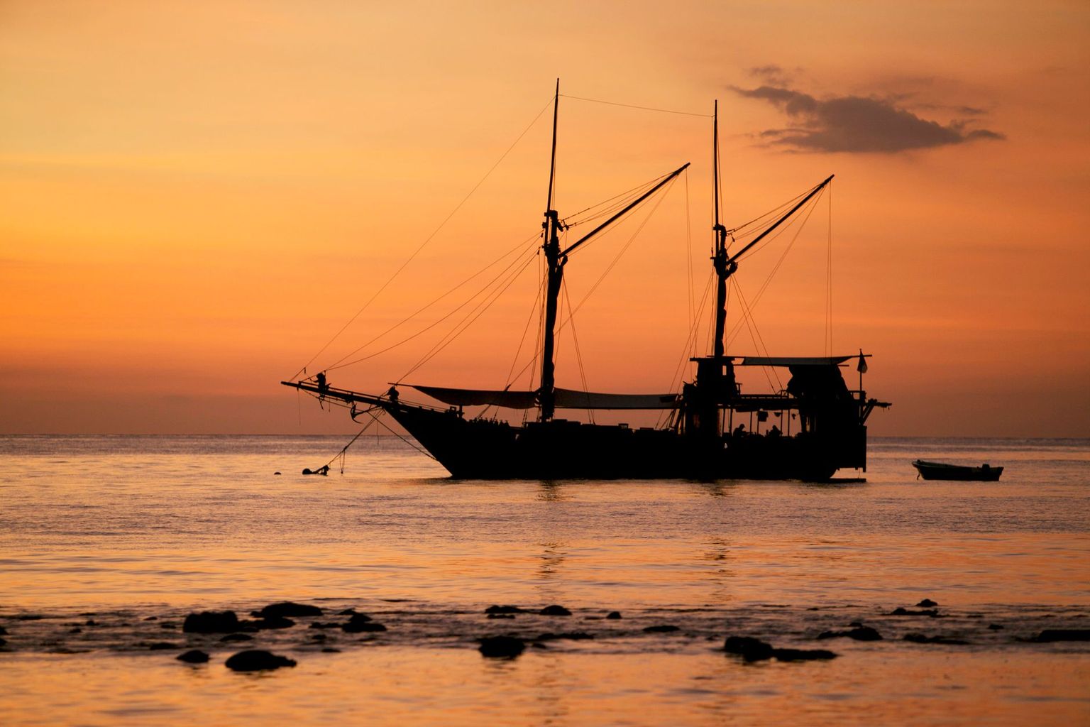 Boat silhouetted against an orange and violet Gulf of Mexico sunset off Naples