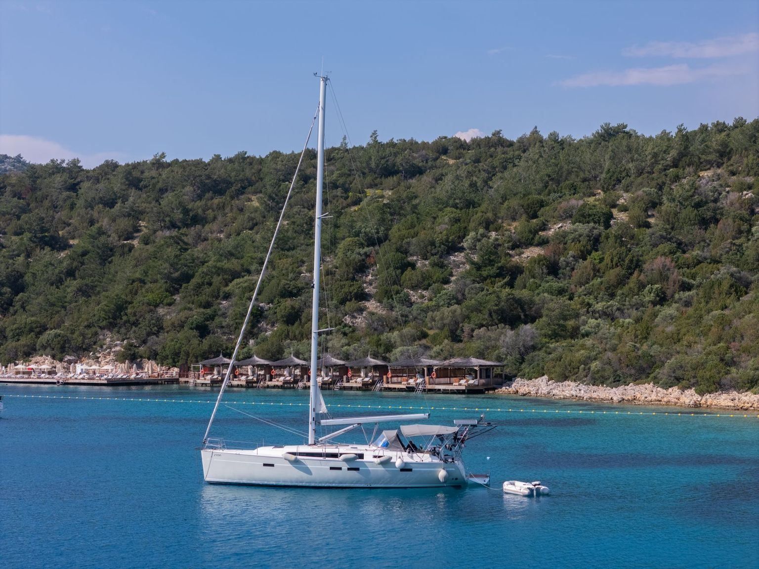 Turquoise Gulf water over a shallow sandbar with an anchored boat under midday sun