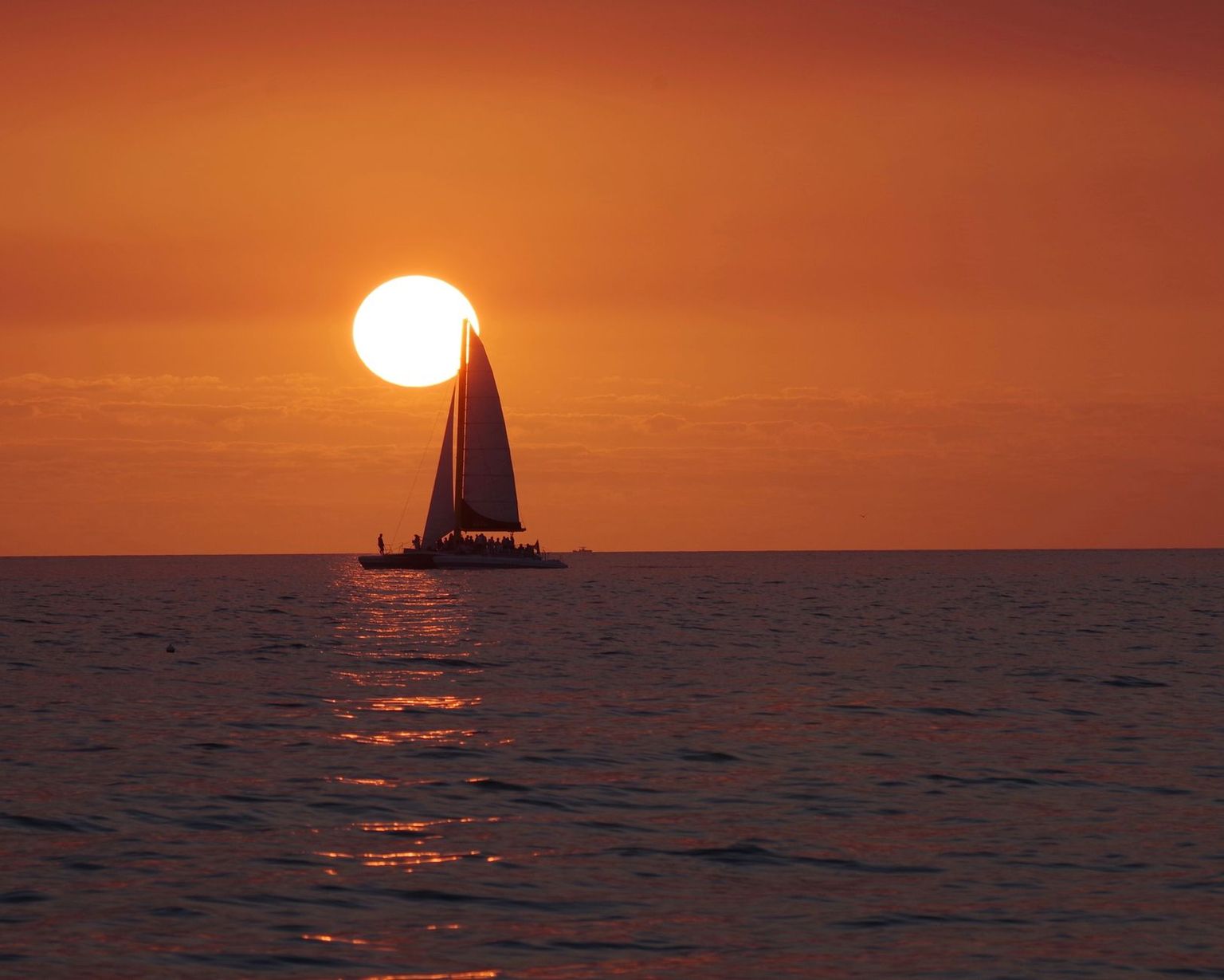 Boat anchored off Keewaydin Island as the sun drops into the Gulf of Mexico