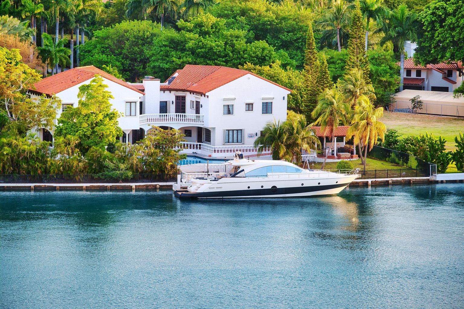 Waterfront estates and private docks lining a Port Royal canal in Naples at golden hour