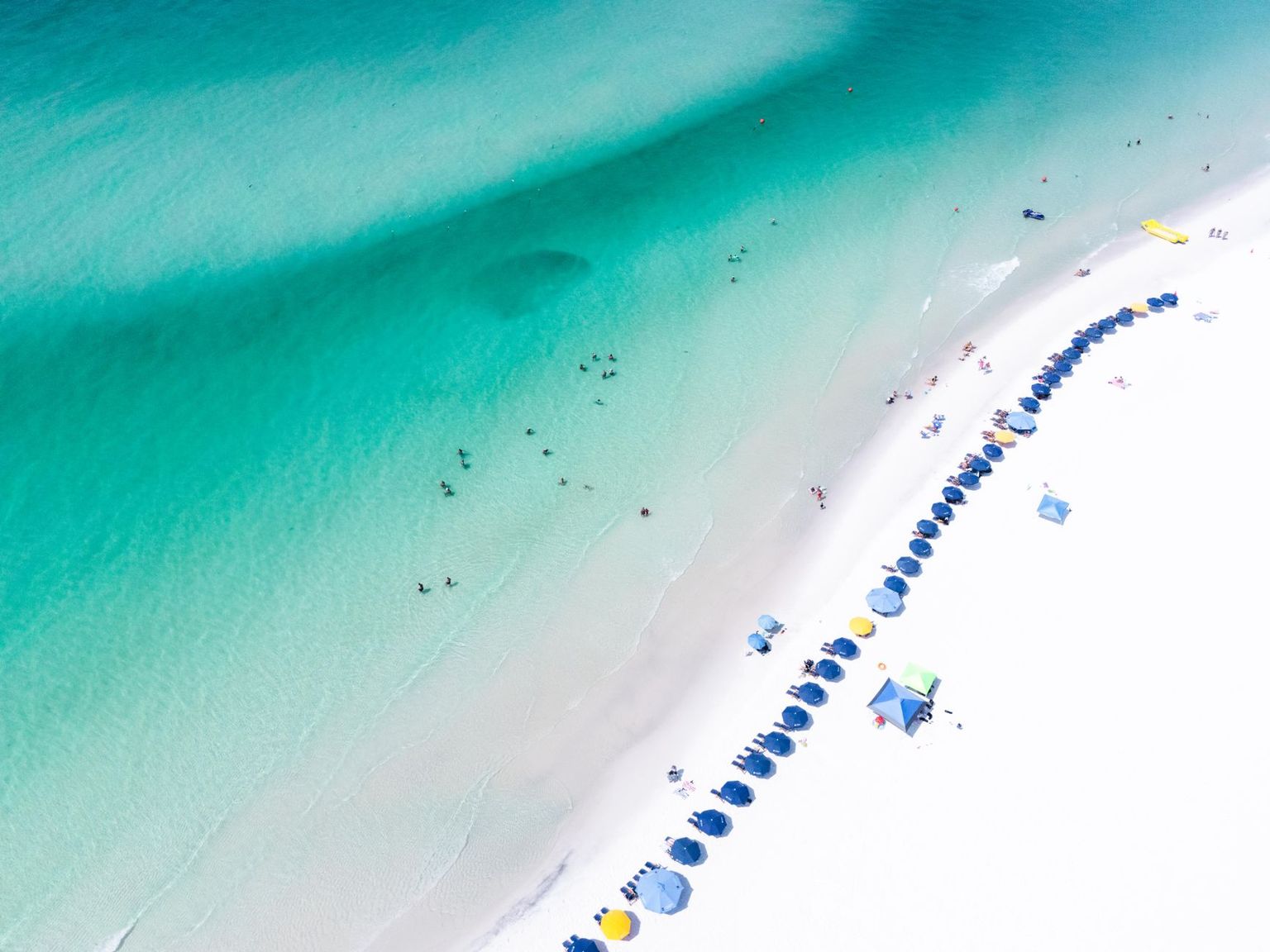 Vanderbilt Beach in North Naples with rental chairs and umbrellas on white sand